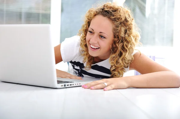 Meisje thuis met laptop liyng op verdieping — Stockfoto