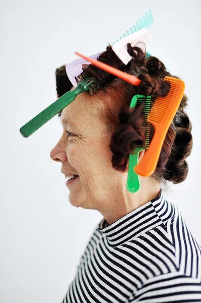 Senior woman with many combs on hair — Stock Photo, Image