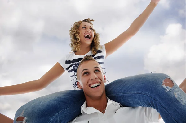 Portrait of teenage couple piggybacking isolated in white — Stock Photo, Image