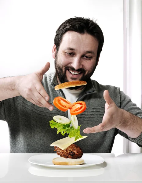 Volwassen man die een hamburger — Stockfoto