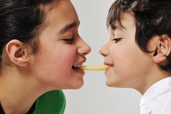Kız ve erkek kardeş patates kızartması yiyen — Stok fotoğraf