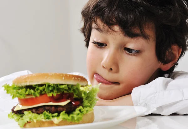 Pojke på frestelse med hamburgare — Stockfoto