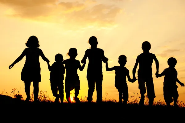 Children running on meadow at sunset — Stock Photo, Image