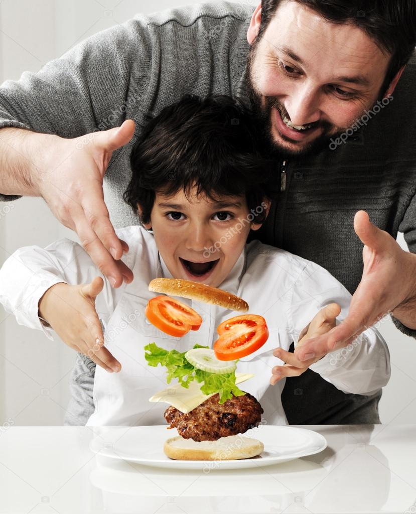 Kid and father making burger together