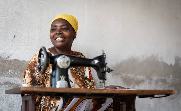 Afrikaanse vrouwelijke kleermaker werken op naaimachine op straat — Stockfoto