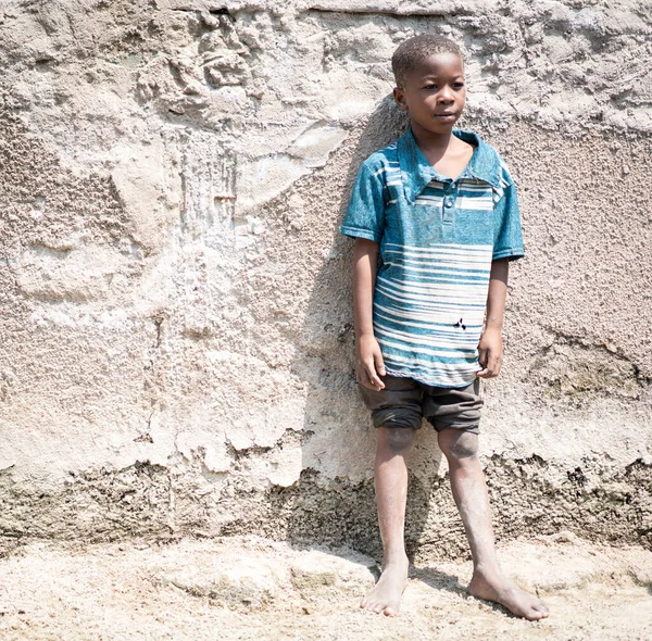 Afrykański czarny chłopiec portret stojący w pobliżu jego biedny dom — Zdjęcie stockowe