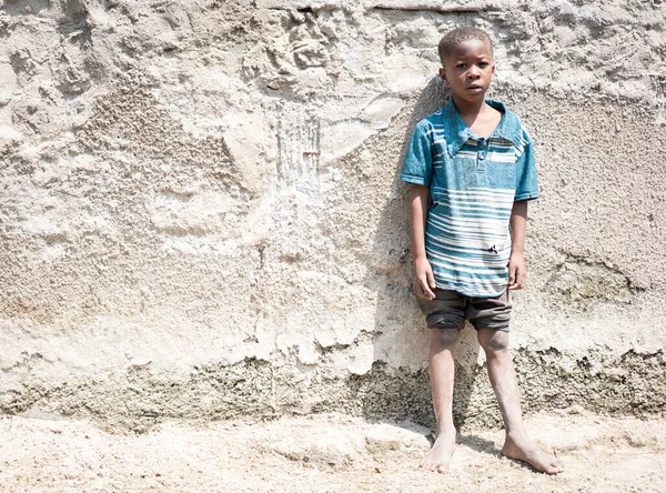 Afrikanisches Porträt eines schwarzen Jungen steht in der Nähe seines armen Hauses — Stockfoto