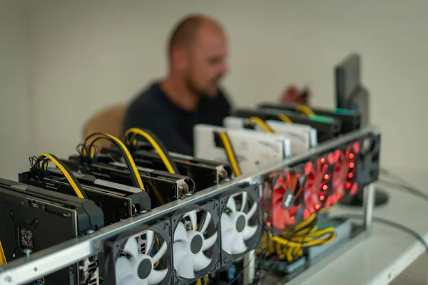 Programador jovem ajustando o equipamento de mineração criptomoeda para configurações operacionais ideais — Fotografia de Stock