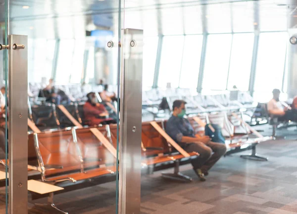 Passageiros embaçados abstratos no fundo do aeroporto com luz natural das janelas do telhado clarabóia — Fotografia de Stock