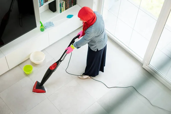 Ευτυχισμένη μουσουλμάνα γυναίκα καθαρισμού σύγχρονο σπίτι σαλόνι Royalty Free Φωτογραφίες Αρχείου