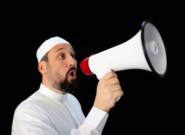 Muslim pilgrim in white traditional clothes, saying message on megaphone Stock Image