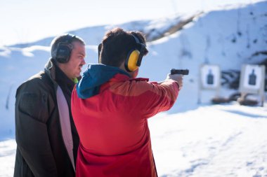 Antrenör, savaş eğitiminde genç insana tabancayla nişan almasında yardım ediyor. Yüksek kalite fotoğraf