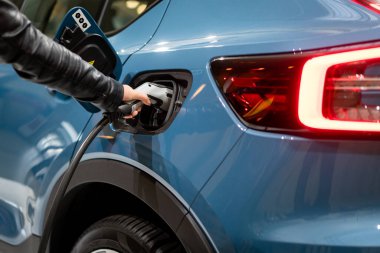 Aküyü şarj etmek için güç kaynağı elektrikli araca bağlanıyor. - Evet. EV yakıt Fişi hibrit arabaya takıldı. 