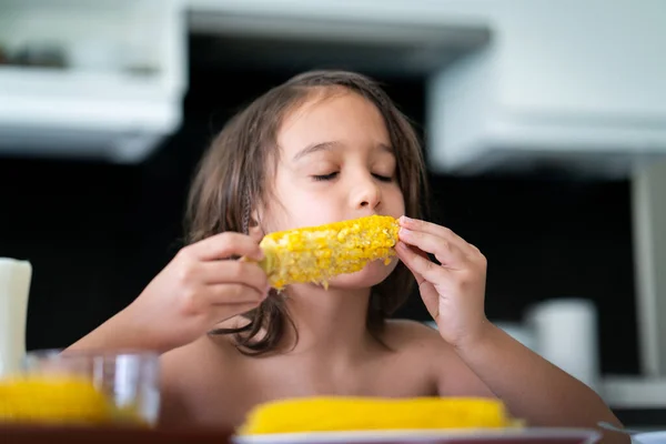 夏のおやつ 小さな男の子が座ってトウモロコシを食べる高品質の写真 — ストック写真