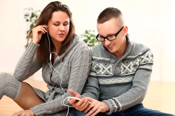 Young couple listening music in headphones