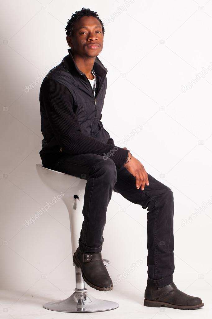 beau mec noir assis sur une chaise — Photographie yekophotostudio