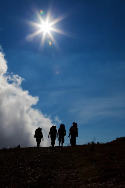 Silhouettes of tourists on against a blue sky