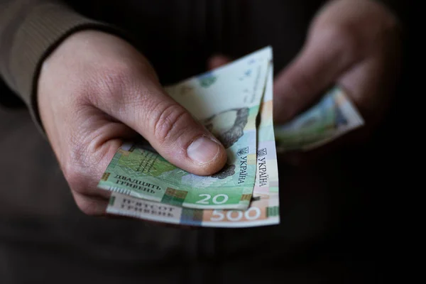 White man giving Ukrainian money bills closeup