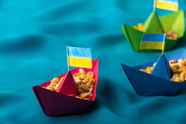 Ships with Ukrainian maize grain made of paper concept