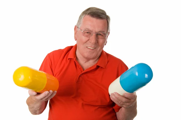 Old man holding big pills — Stock Photo, Image