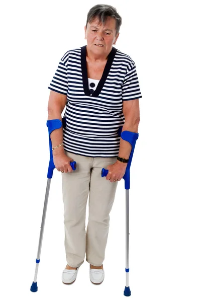 Old woman walking on crutches — Stock Photo, Image