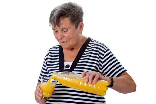 Старшая женщина с апельсиновым соком — стоковое фото