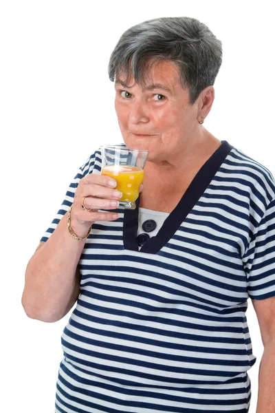 Старшая женщина пьет апельсиновый сок — стоковое фото