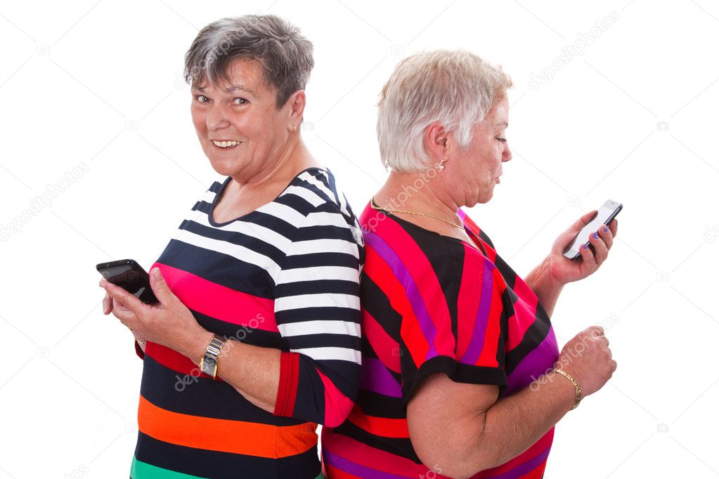 Two senior women communicating with cellphones
