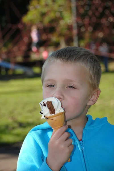 Criança comendo grito de gelo no parque — Fotografia de Stock