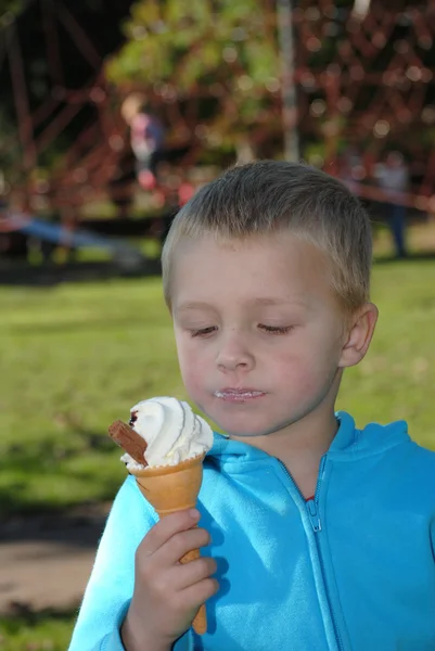 Criança comendo grito de gelo no parque — Fotografia de Stock