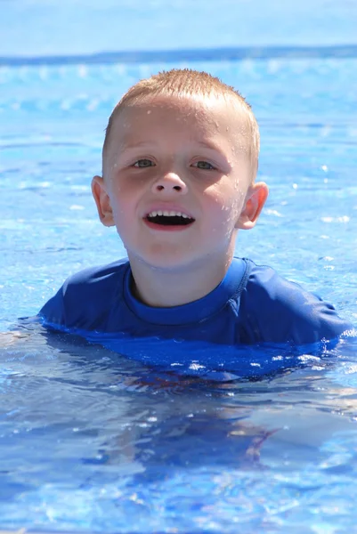 Kleine jongen ontspannen in het zwembad — Stockfoto