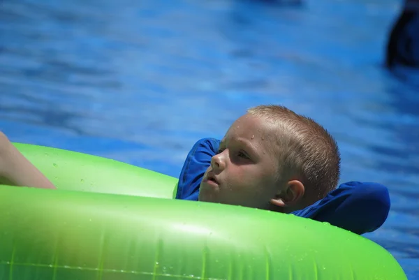 Liten pojke avkopplande i poolen — Stockfoto