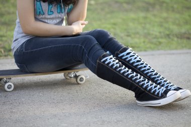 kadın, yüksek diz spor ayakkabı içinde kaykay.