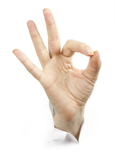 Fingers showing ok sign bursting through paper — Stock Photo, Image