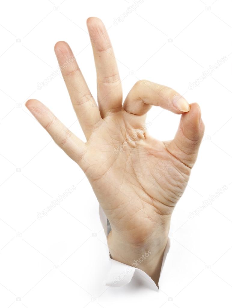 Fingers showing ok sign bursting through paper