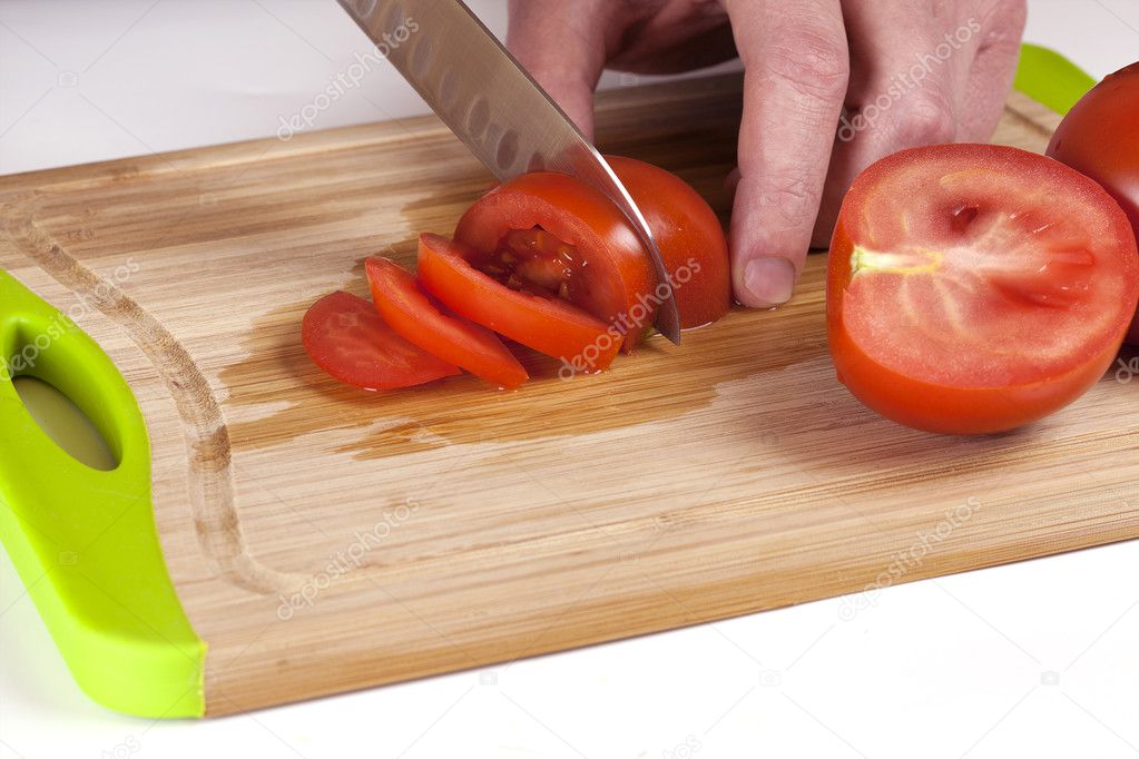 Chef Hand and Knife Slicing Tomato