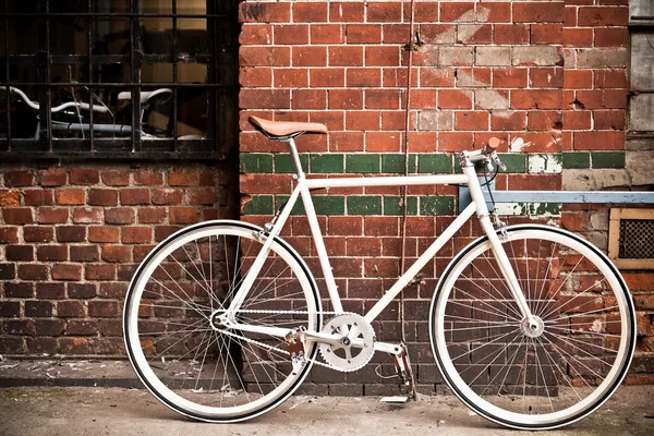 Bicicletta da città su muro rosso, stile vintage — Foto Stock