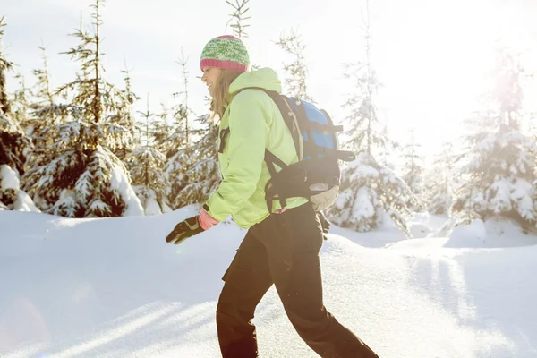 Femme marchant dans les montagnes d'hiver avec coucher de soleil — Photo