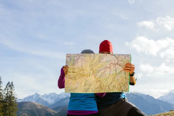 Pareja de senderismo con mapa en las montañas — Foto de Stock