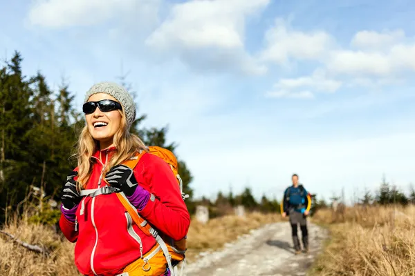 Pareja caminando y senderismo en sendero de montaña Imágenes de stock libres de derechos