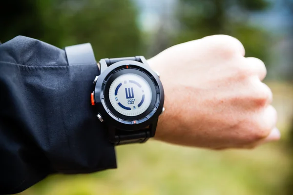 Hiker on mountain trail checking compass — Stock Photo, Image