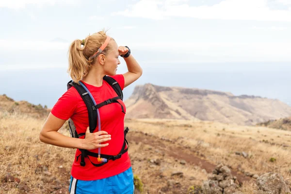 Jovem mulher corredor na trilha em montanhas — Fotografia de Stock