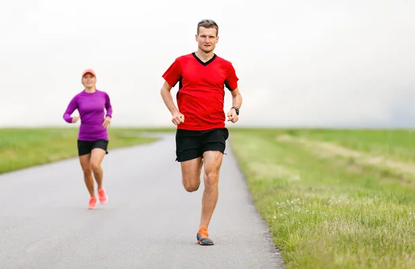 Pareja corriendo por el camino del campo — Foto de Stock