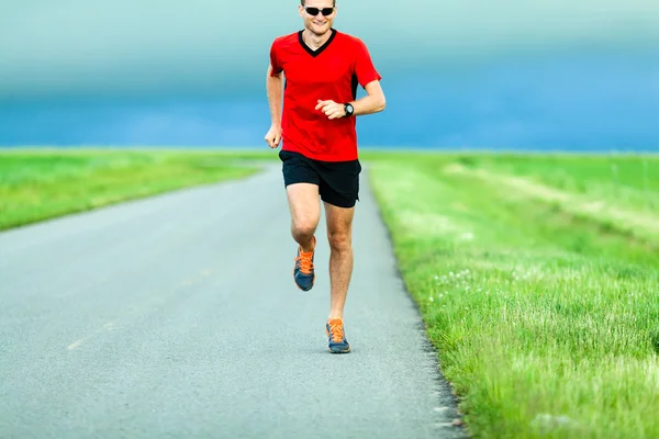 Homem correndo na estrada do país — Fotografia de Stock