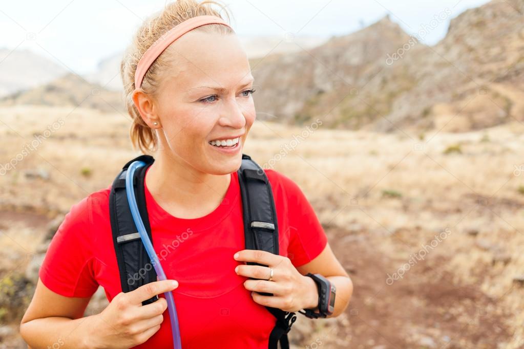 Young woman running in mountains on sunny day