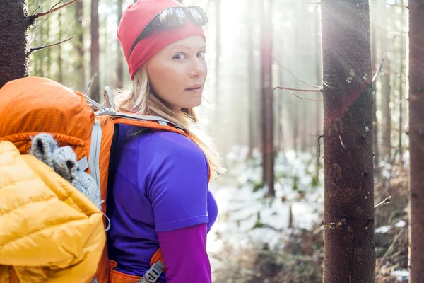 Frau wandert im winterlichen Waldlicht — Stockfoto