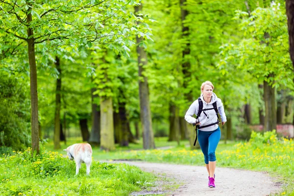 Donna corridore a piedi con cane nel parco estivo — Foto Stock