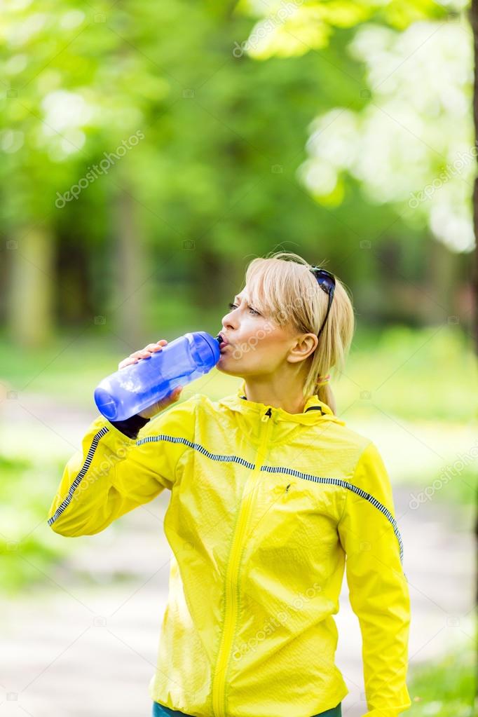 Female runner drinking water