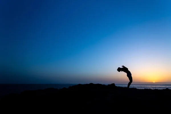 Vrouw doen yoga zonsondergang silhouet — Stockfoto