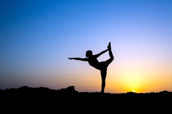 Vrouw doen yoga zonsondergang silhouet — Stockfoto